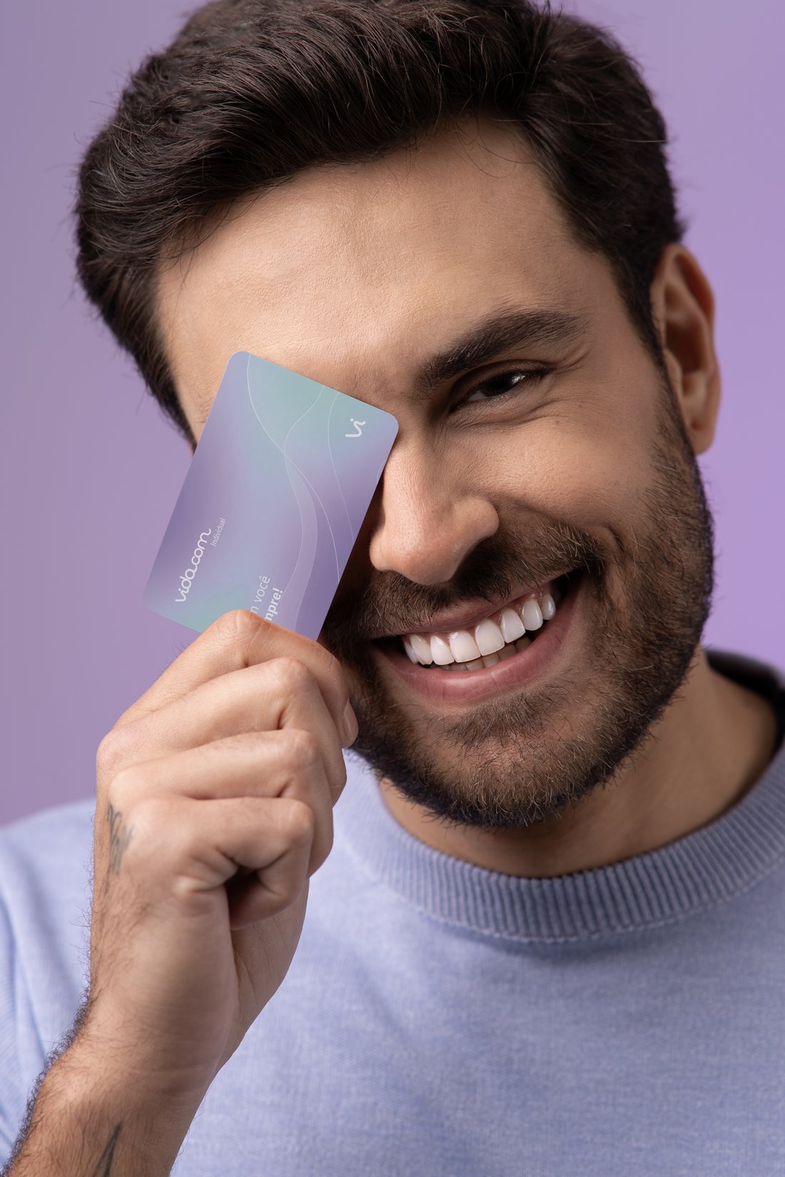 Homem sorrindo segurando o cartão de benefícios vida.com