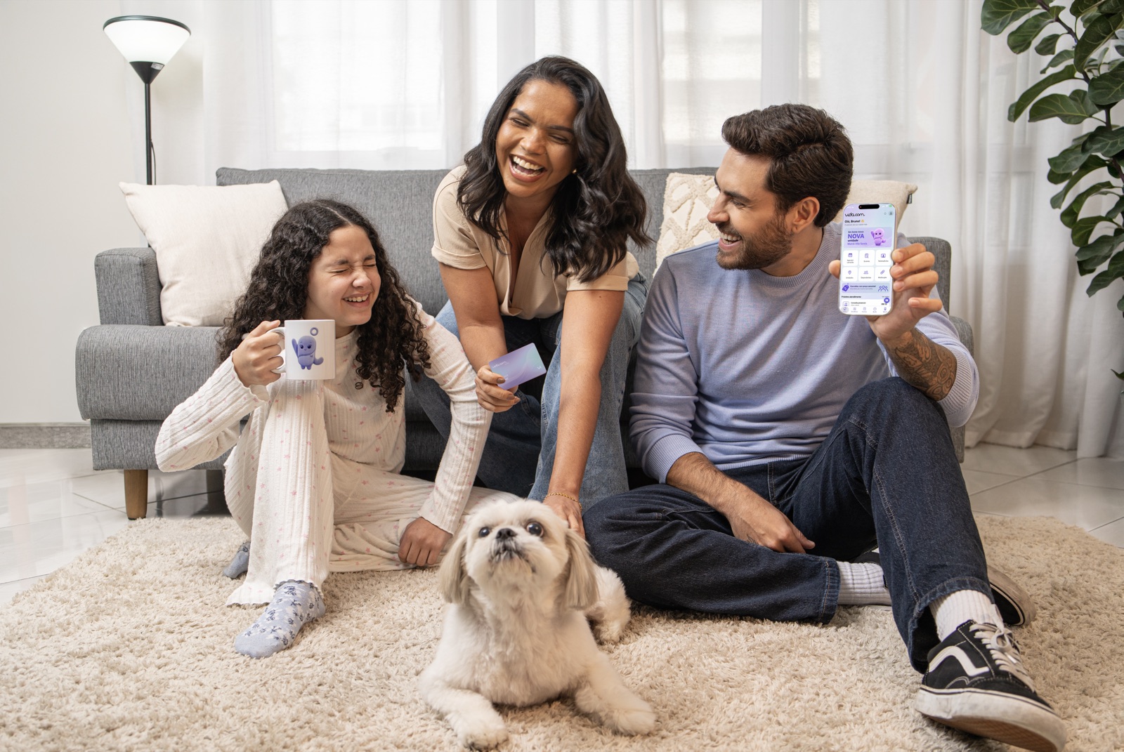 Família reunida na sala com o app vida.com no celular e o cachorro no tapete